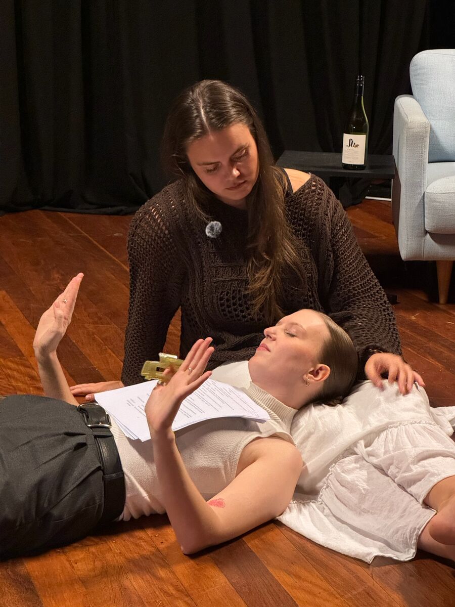 Two actors share a quiet moment on the floor during the reading.